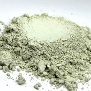 Close-up of a mound of gray powder on a white surface.